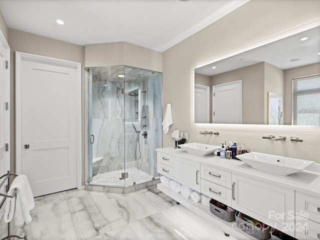 bathroom with dual sinks, a shower with door, tile floors, and vanity with extensive cabinet space