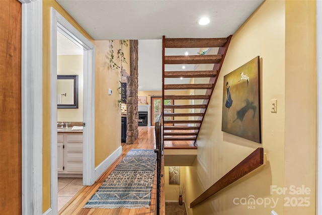 hall featuring light tile patterned floors and sink