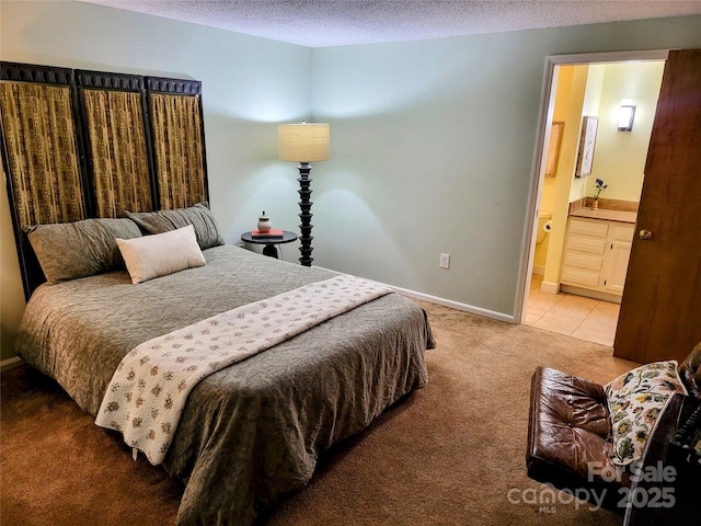 bedroom with connected bathroom, a textured ceiling, and carpet