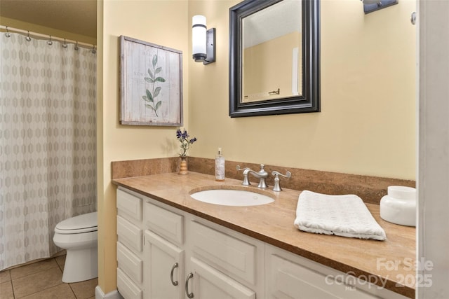 bathroom with tile patterned flooring, vanity, toilet, and walk in shower