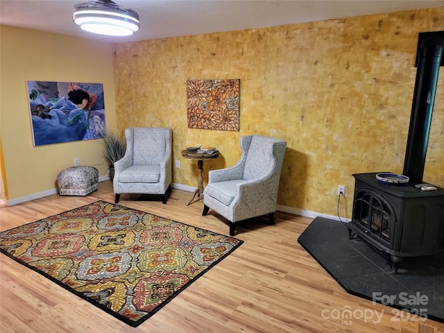 living area with hardwood / wood-style flooring and a wood stove