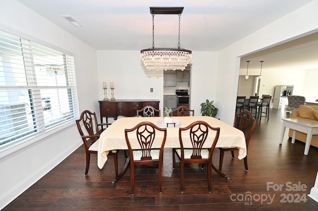 dining space with a notable chandelier, a wealth of natural light, and dark wood-type flooring