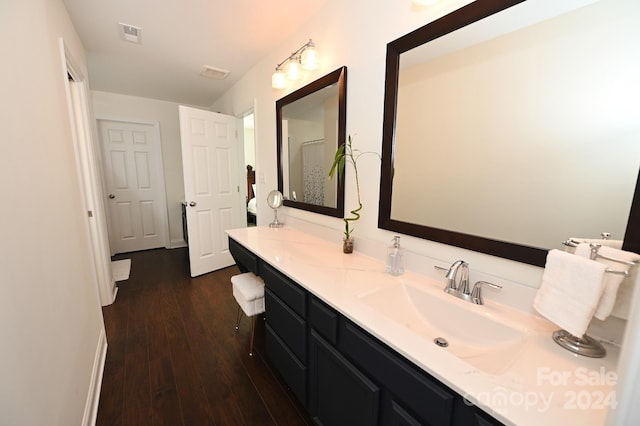 bathroom featuring vanity with extensive cabinet space and hardwood / wood-style flooring