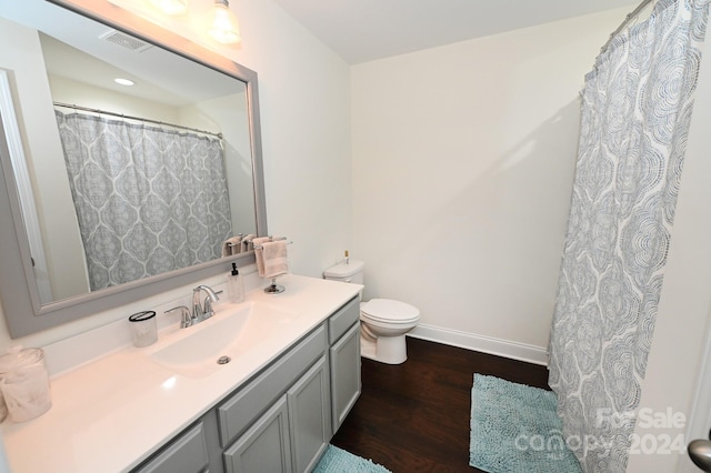 bathroom featuring toilet, vanity, and hardwood / wood-style floors