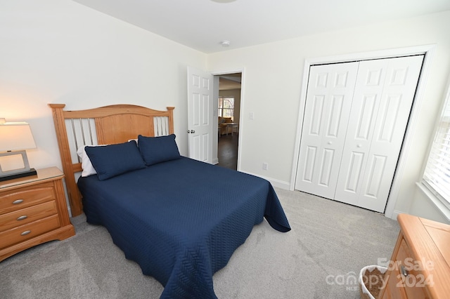 carpeted bedroom featuring a closet and multiple windows