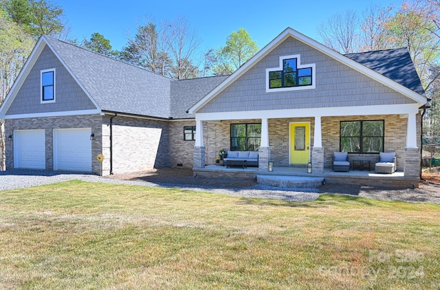 craftsman-style house featuring a garage, a front lawn, and a porch