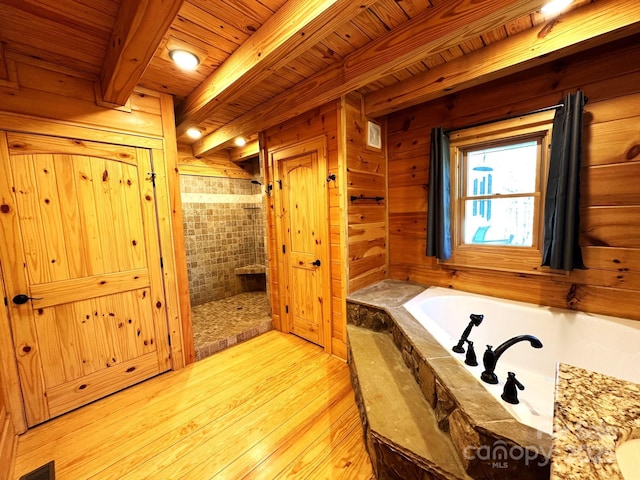 bathroom with beamed ceiling, shower with separate bathtub, wooden ceiling, and wooden walls