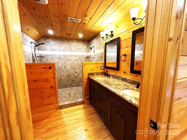 bathroom featuring vanity, wooden walls, wooden ceiling, and walk in shower