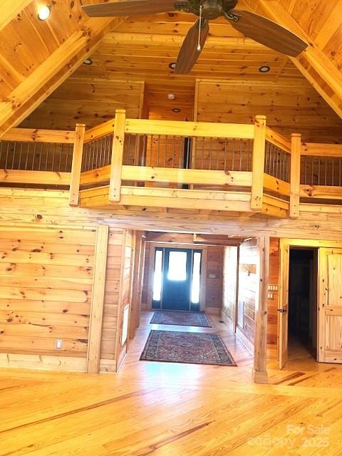 interior space featuring hardwood / wood-style flooring, wooden ceiling, high vaulted ceiling, and wood walls