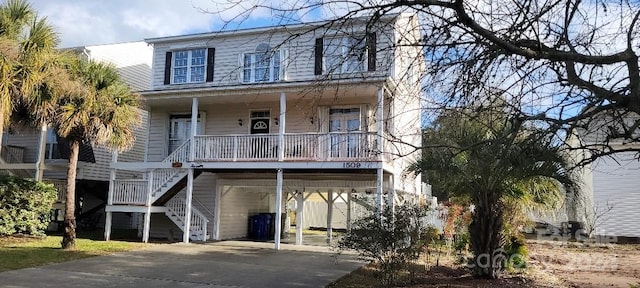 coastal home featuring central AC, covered porch, and a carport