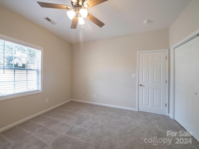 spare room featuring ceiling fan and light colored carpet