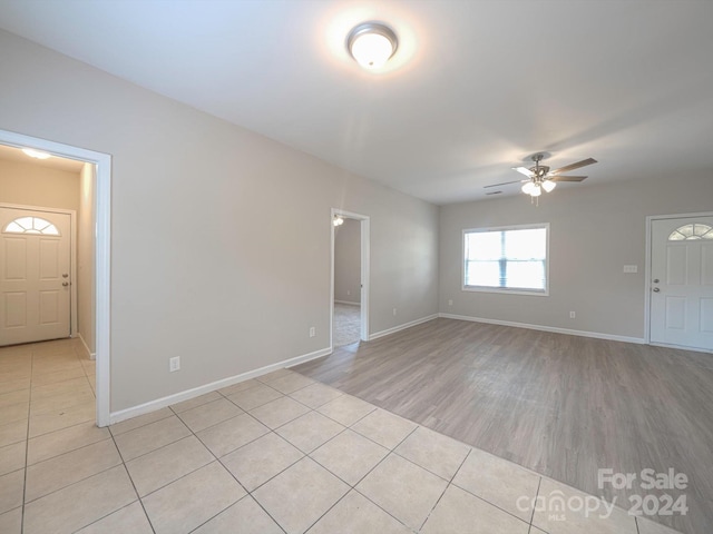 unfurnished living room with ceiling fan and light wood-type flooring