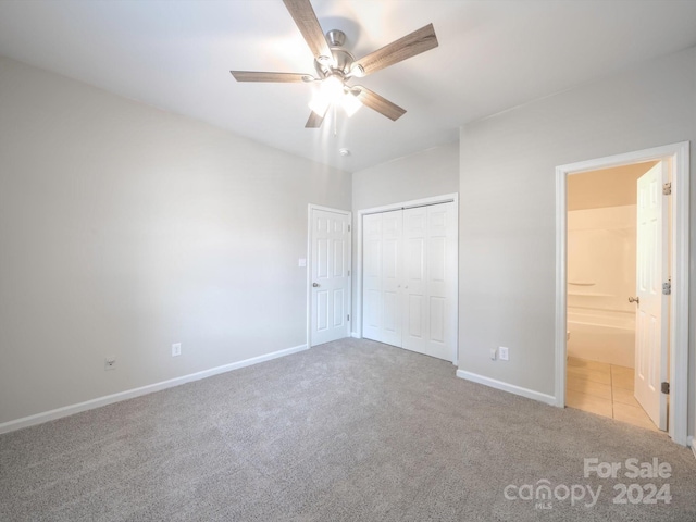 unfurnished bedroom featuring ceiling fan, a closet, light carpet, and ensuite bathroom