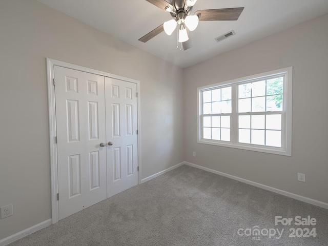 unfurnished bedroom featuring a closet, ceiling fan, and carpet flooring