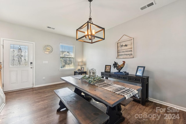 dining room featuring dark wood-type flooring and a chandelier