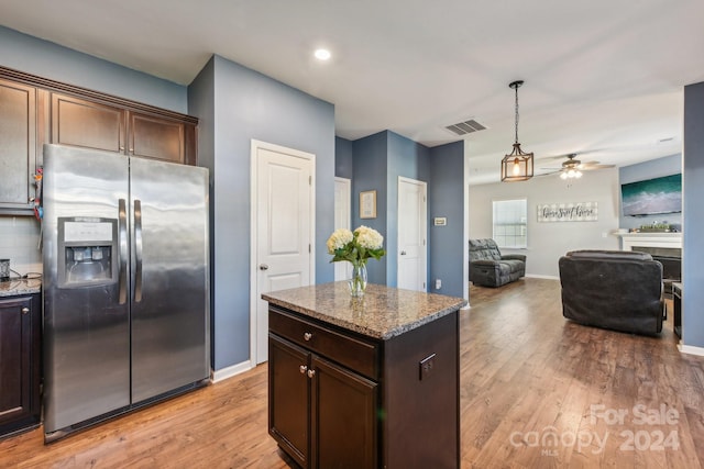 kitchen with dark brown cabinets, dark stone countertops, light hardwood / wood-style flooring, and stainless steel refrigerator with ice dispenser