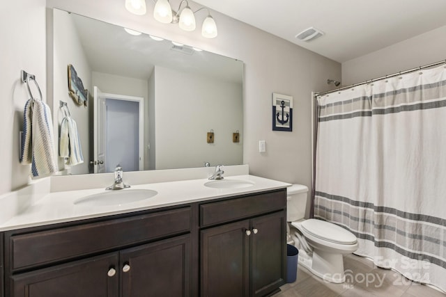 bathroom with a shower with shower curtain, vanity, toilet, and tile patterned floors