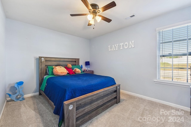 bedroom featuring multiple windows, ceiling fan, and light colored carpet