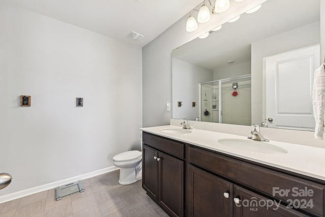 bathroom with a shower with shower door, vanity, and toilet