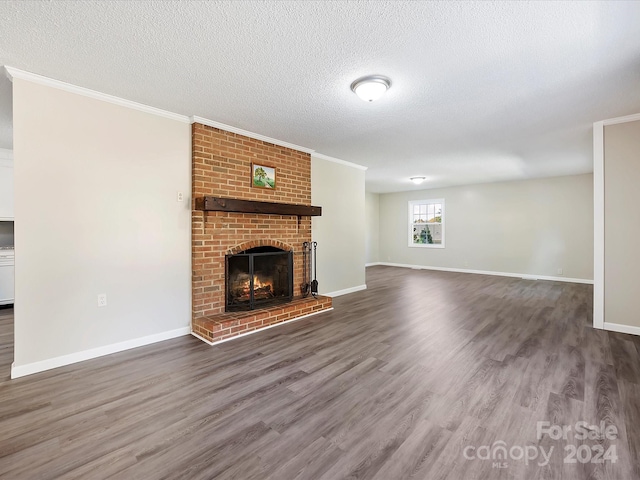 unfurnished living room with a brick fireplace, a textured ceiling, crown molding, and dark hardwood / wood-style flooring