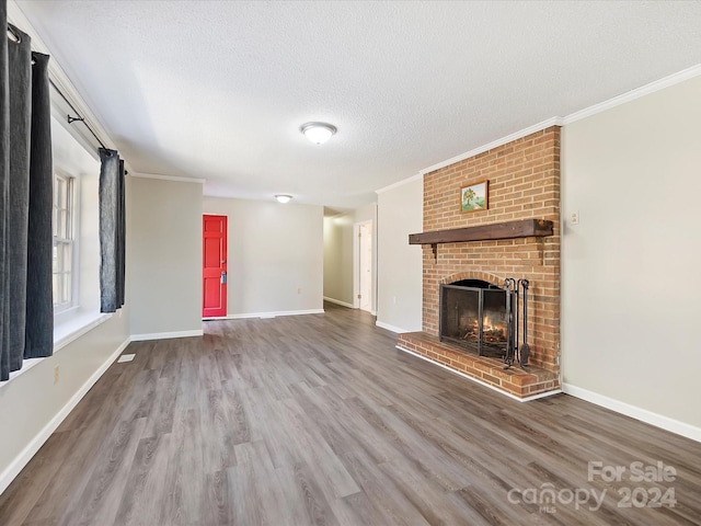 unfurnished living room with crown molding, hardwood / wood-style floors, a textured ceiling, and a fireplace