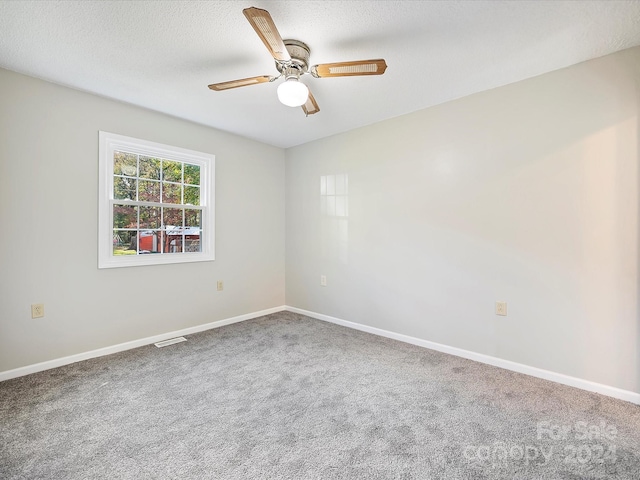 carpeted empty room with a textured ceiling and ceiling fan