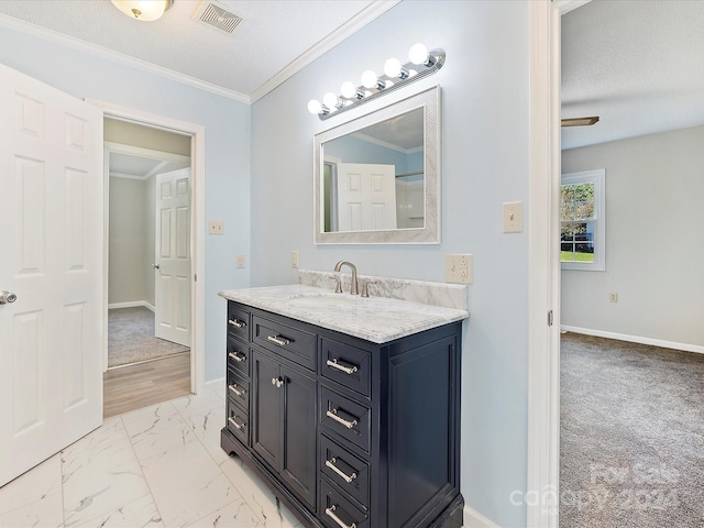 bathroom featuring vanity, crown molding, and a textured ceiling