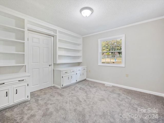 unfurnished bedroom featuring crown molding, light carpet, and a textured ceiling