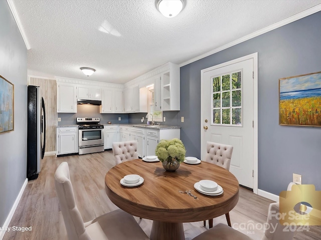 dining area with ornamental molding, sink, a textured ceiling, and light hardwood / wood-style floors