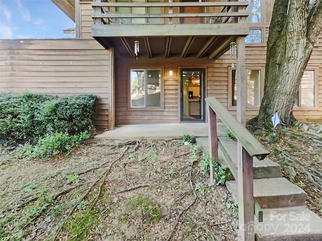 view of exterior entry featuring a balcony