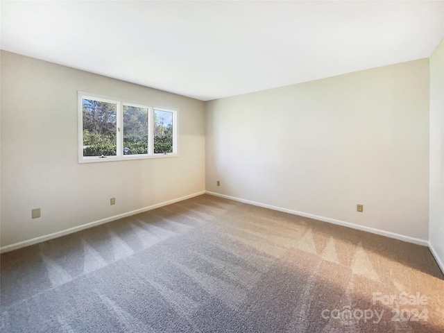 spare room featuring dark colored carpet