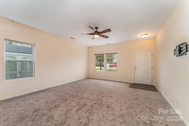 empty room with ceiling fan and carpet flooring