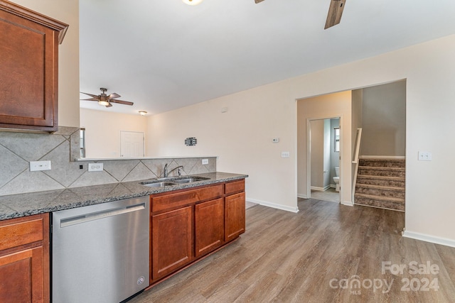 kitchen with light hardwood / wood-style floors, ceiling fan, dark stone countertops, dishwasher, and sink