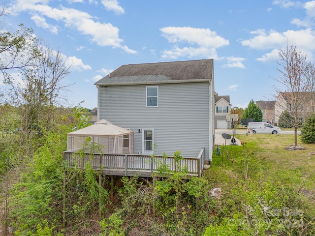 rear view of house featuring a wooden deck and a gazebo