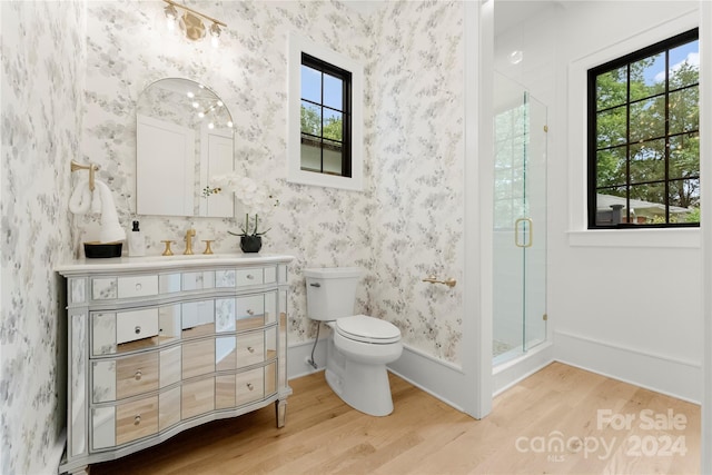 bathroom with a shower with door, hardwood / wood-style floors, toilet, and vanity