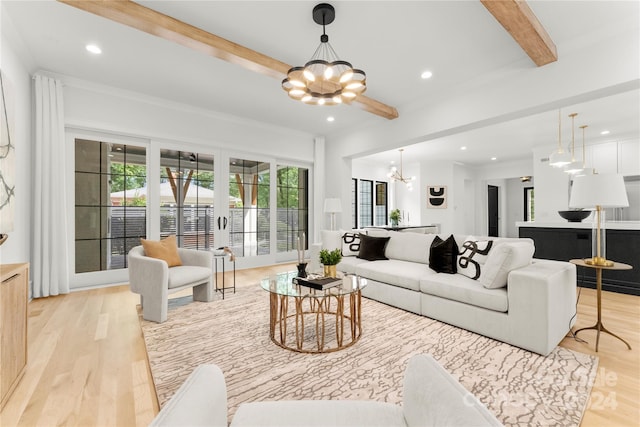 living room with beam ceiling, a chandelier, a wealth of natural light, and light hardwood / wood-style flooring