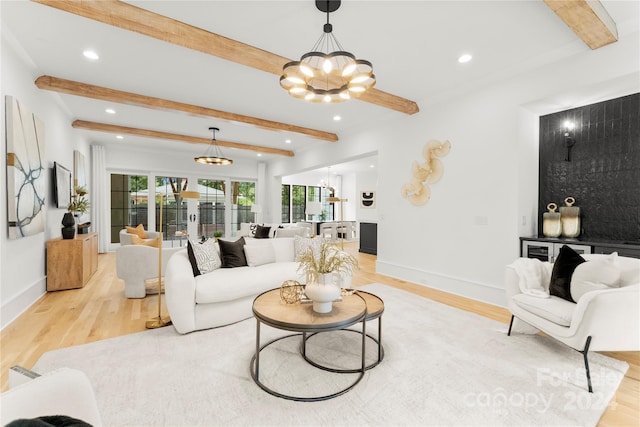 living room with beamed ceiling, a chandelier, and light hardwood / wood-style flooring