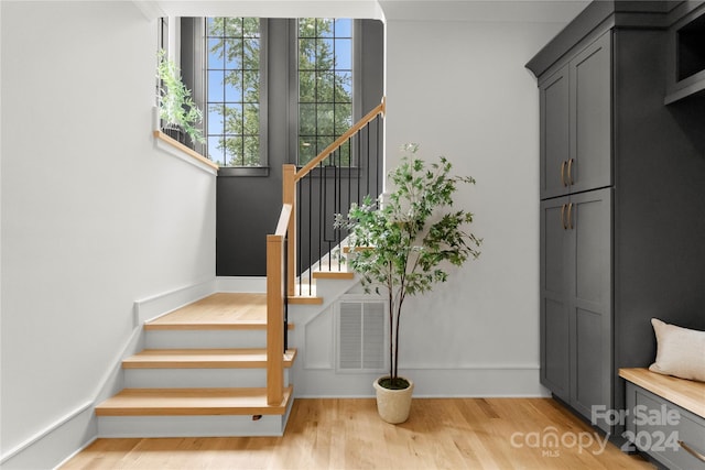 stairway with light hardwood / wood-style floors