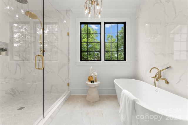 bathroom featuring a healthy amount of sunlight, an inviting chandelier, separate shower and tub, and tile floors