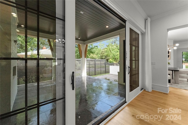 entryway featuring a wealth of natural light, ornamental molding, and hardwood / wood-style flooring