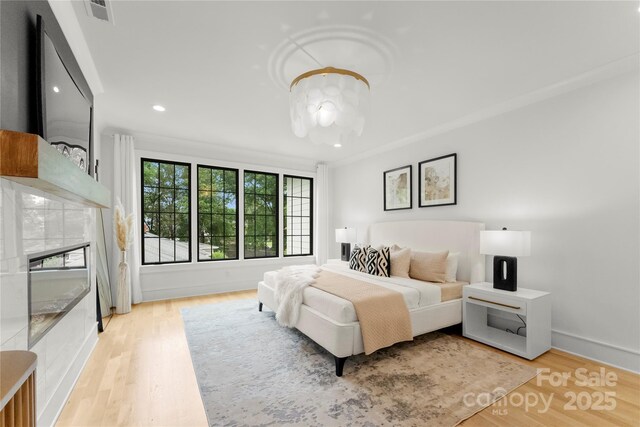 4142 Pineview Rd, Charlotte, NC 28211 - bedroom featuring light wood-type flooring, recessed lighting, a chandelier, a glass covered fireplace, and baseboards