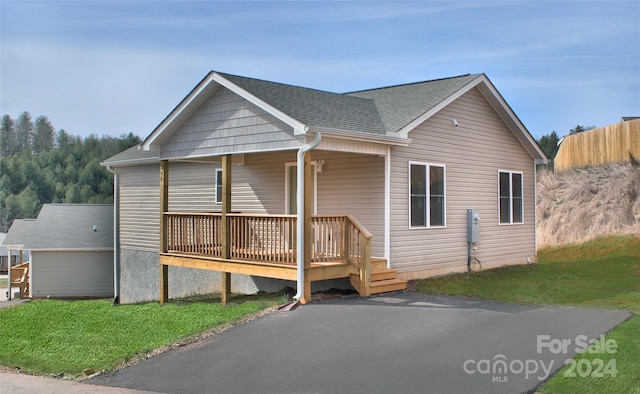 view of front of home with a wooden deck and a front yard