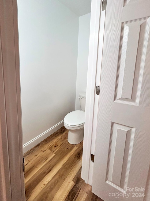 bathroom with hardwood / wood-style flooring and toilet