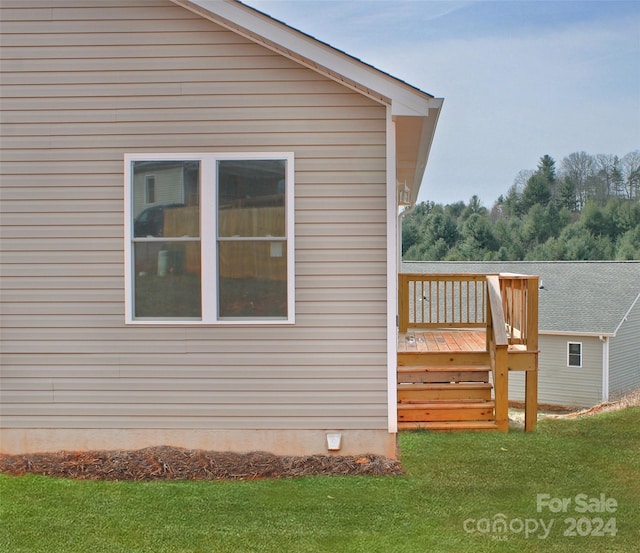 view of property exterior with a lawn and a deck