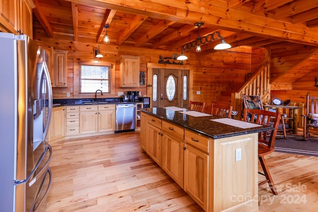 kitchen with appliances with stainless steel finishes, a center island, sink, light hardwood / wood-style floors, and beam ceiling