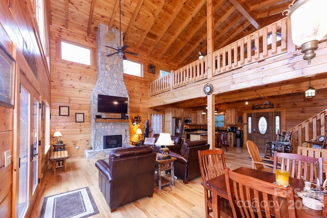 living room with wooden walls, a healthy amount of sunlight, high vaulted ceiling, and wooden ceiling