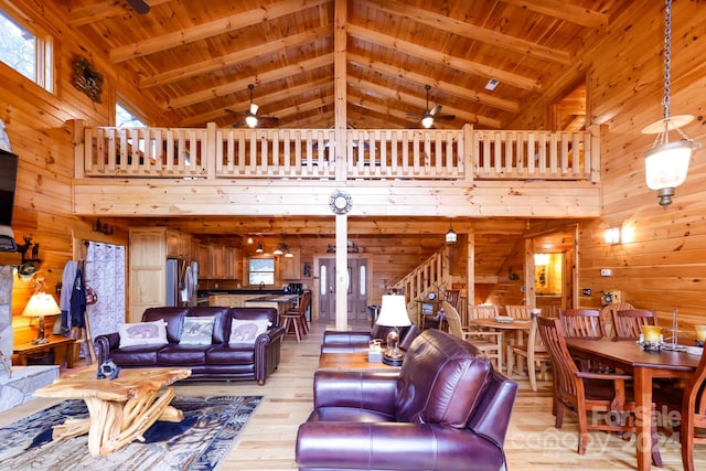 living room with wood ceiling, high vaulted ceiling, ceiling fan, and wooden walls