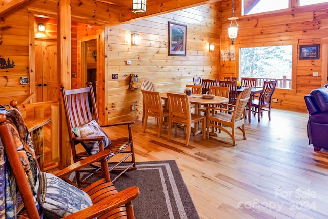 dining room featuring wood walls and light wood-type flooring