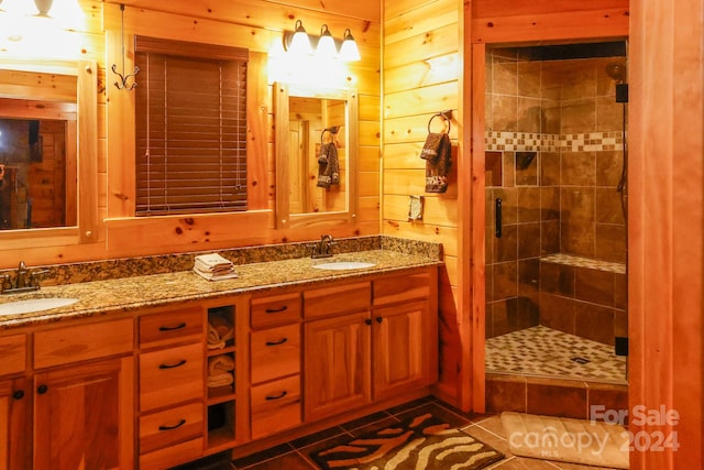 bathroom featuring tile flooring, tiled shower, and dual bowl vanity