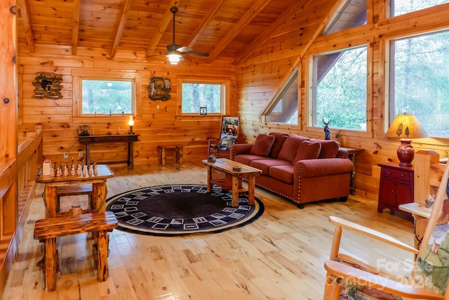 living room with vaulted ceiling with beams, a healthy amount of sunlight, and light wood-type flooring